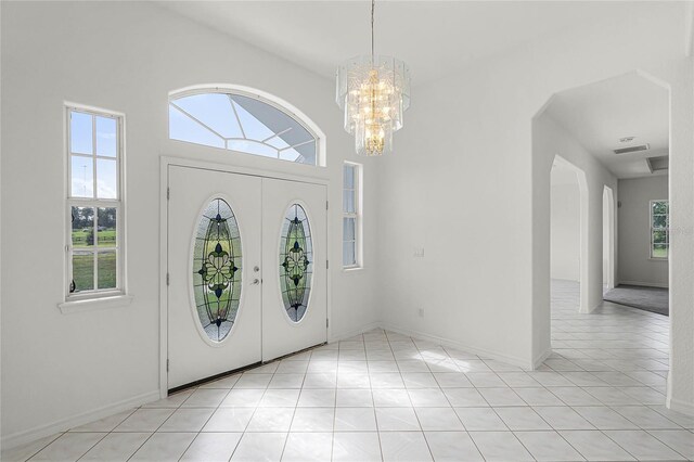 foyer entrance with a chandelier and light tile patterned flooring