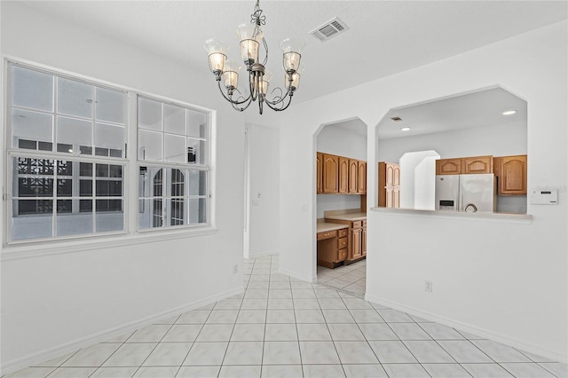 interior space with an inviting chandelier and light tile patterned flooring