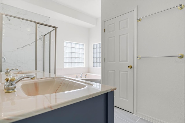 bathroom with vanity and shower with separate bathtub