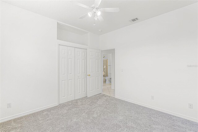 unfurnished bedroom featuring light carpet, a closet, and ceiling fan