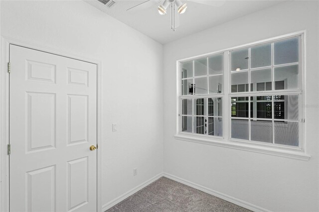 carpeted spare room featuring ceiling fan