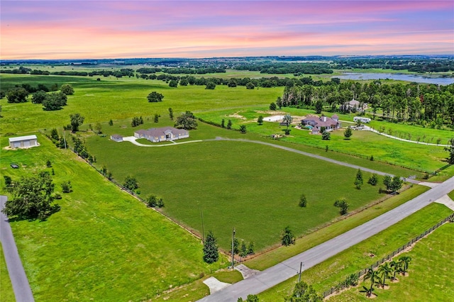 aerial view at dusk with a water view and a rural view