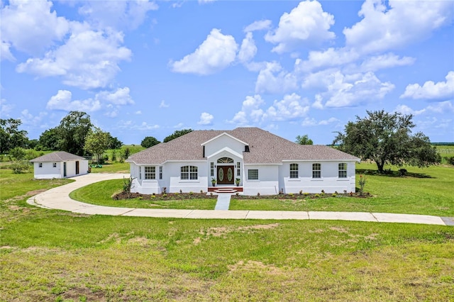 single story home with a garage, an outdoor structure, and a front yard