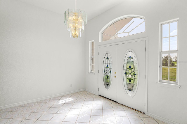 entryway with a chandelier, vaulted ceiling, and light tile patterned floors