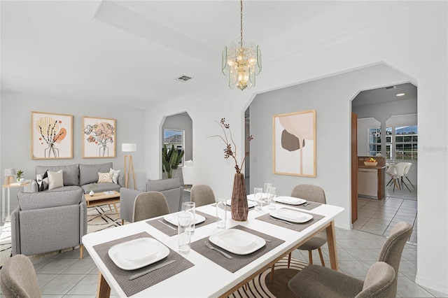 tiled dining area with an inviting chandelier