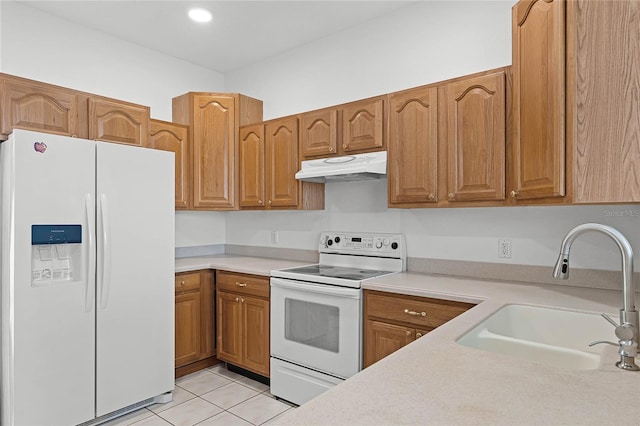 kitchen with light tile patterned floors, white appliances, and sink