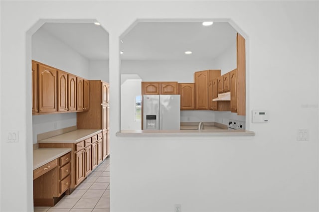 kitchen featuring light tile patterned floors and white fridge with ice dispenser