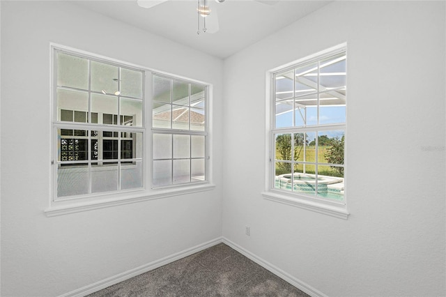 carpeted spare room featuring ceiling fan