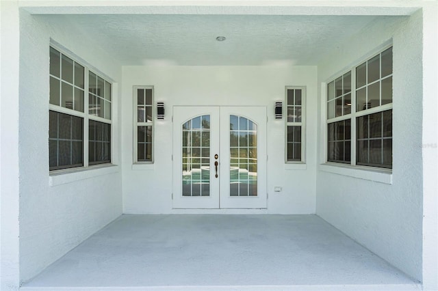 property entrance with a patio area and french doors