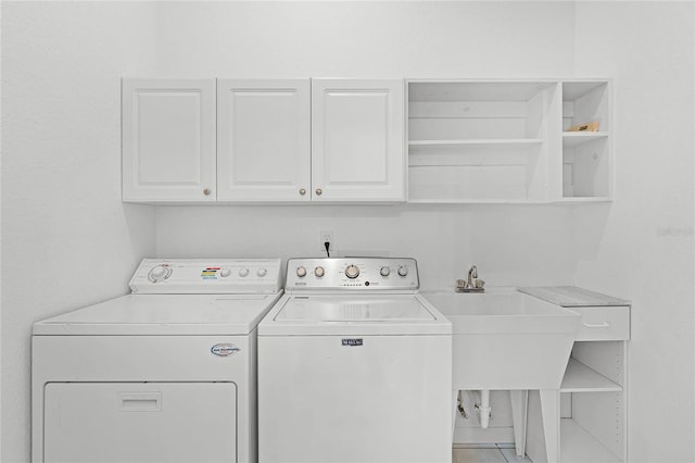 laundry room featuring tile patterned floors, washing machine and dryer, sink, and cabinets