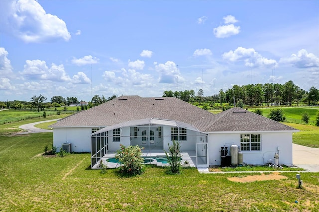 rear view of house with a lanai, central AC, a patio area, and a lawn