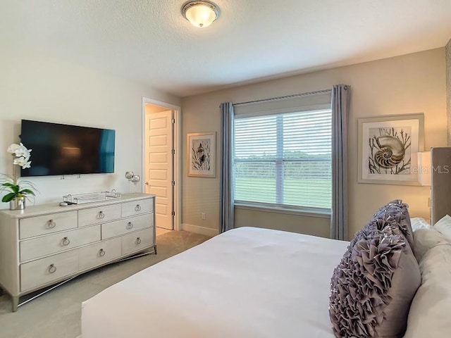 carpeted bedroom featuring multiple windows and a textured ceiling