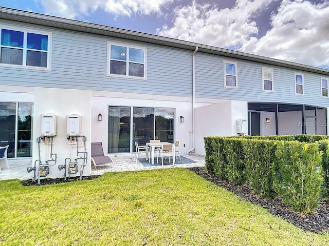 back of property featuring a patio and a lawn