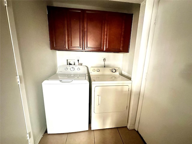 laundry area featuring cabinets, washing machine and dryer, and light tile patterned floors