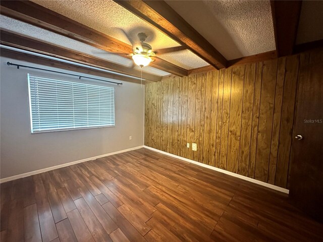 spare room with beamed ceiling, a textured ceiling, ceiling fan, and hardwood / wood-style floors