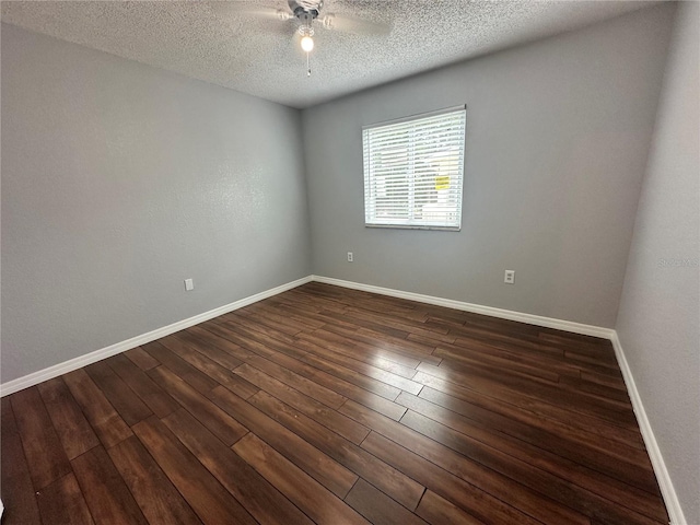 empty room with ceiling fan, dark hardwood / wood-style floors, and a textured ceiling