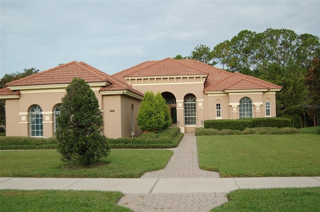 mediterranean / spanish home with a front lawn