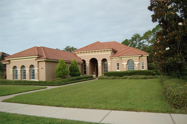 mediterranean / spanish house with a front lawn