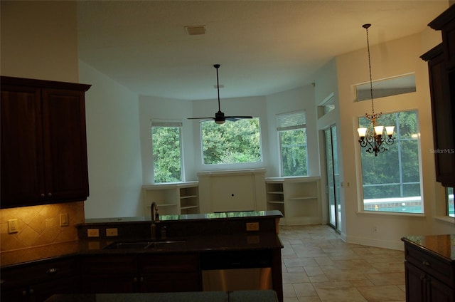 kitchen with tasteful backsplash, sink, dark brown cabinetry, and hanging light fixtures