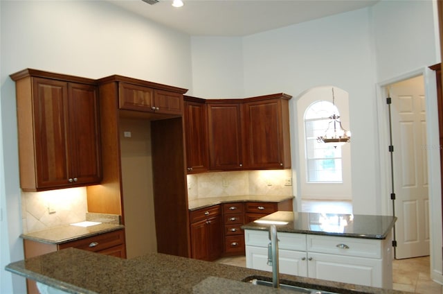 kitchen featuring a notable chandelier, light tile patterned floors, and backsplash