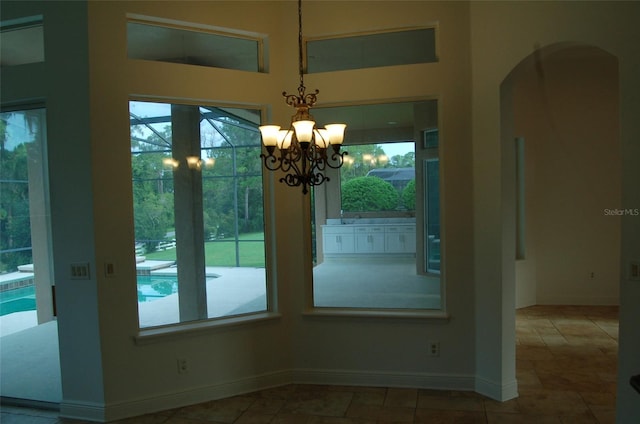 unfurnished dining area with an inviting chandelier and plenty of natural light