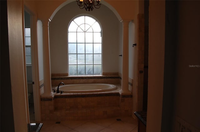 bathroom featuring tile patterned flooring, tiled bath, and decorative columns