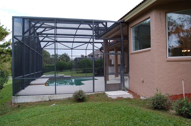 view of swimming pool featuring glass enclosure and a lawn