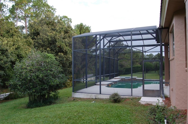 exterior space with glass enclosure and a lawn