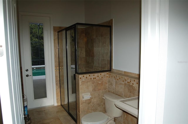 bathroom with toilet, a shower with shower door, and sink