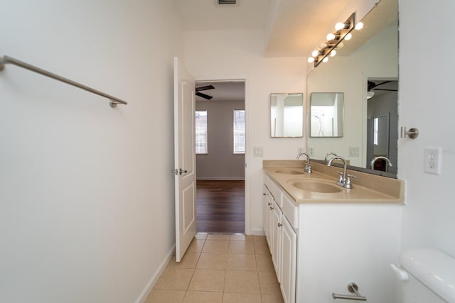 bathroom featuring toilet, double vanity, ceiling fan, and tile patterned flooring