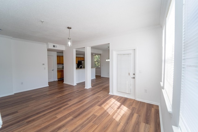 unfurnished living room with ornamental molding, wood-type flooring, and a textured ceiling