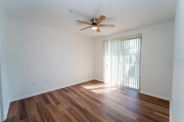 empty room featuring dark wood-type flooring and ceiling fan