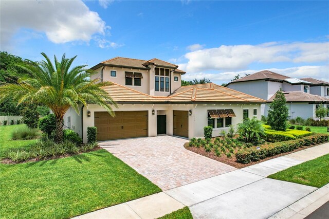 mediterranean / spanish house featuring a front yard and a garage