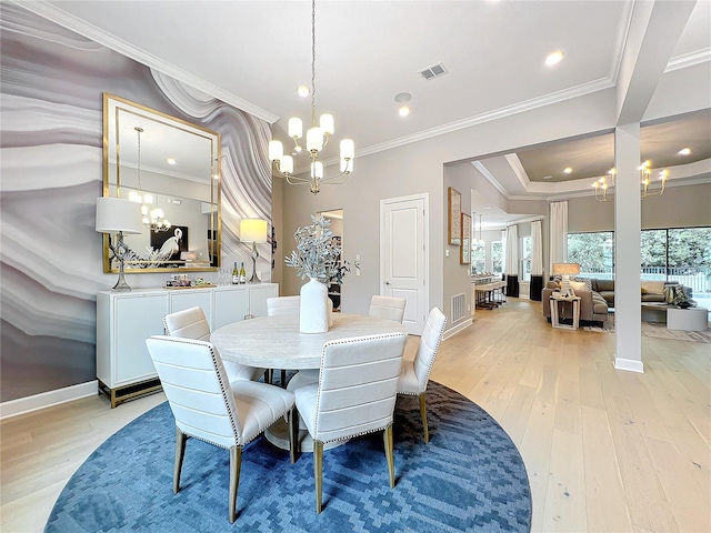 dining space with crown molding, light hardwood / wood-style flooring, and an inviting chandelier