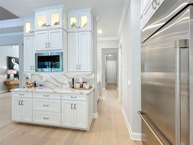 kitchen featuring built in appliances, crown molding, light wood-type flooring, and white cabinets