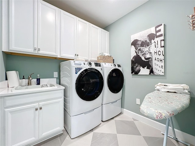 clothes washing area with cabinets, sink, and washing machine and clothes dryer