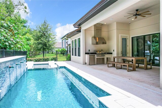 view of swimming pool with a patio area, an outdoor kitchen, a grill, and ceiling fan