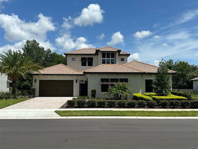 10193 Brocksport Cir, Gotha, FL 34734 - view of front of house featuring an attached garage, decorative driveway, stucco siding, and a tiled roof