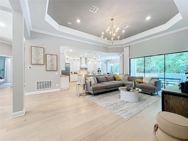 10193 Brocksport Cir, Gotha, FL 34734 - living room featuring a chandelier, a raised ceiling, light wood-style floors, crown molding, and recessed lighting