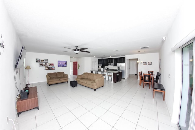 tiled living room with a textured ceiling and ceiling fan