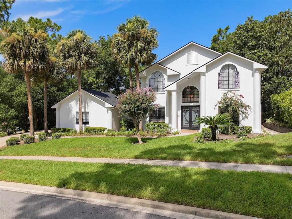 view of front of home with a front lawn and french doors