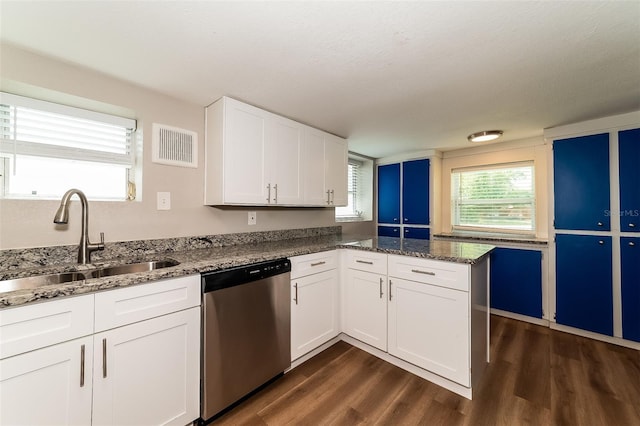 kitchen featuring dishwasher, white cabinetry, dark hardwood / wood-style flooring, dark stone countertops, and sink