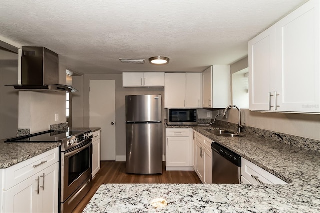 kitchen with white cabinets, wall chimney exhaust hood, stainless steel appliances, sink, and stone counters