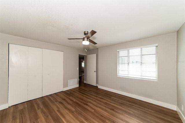 unfurnished bedroom featuring a closet, ceiling fan, and dark wood-type flooring