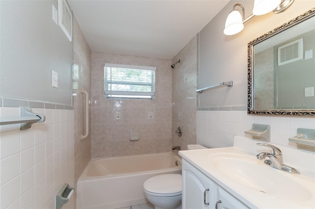 full bathroom featuring vanity, toilet, tile walls, and tiled shower / bath