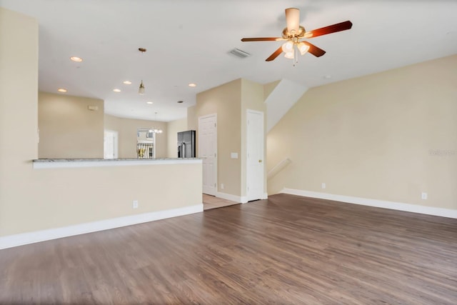 unfurnished living room with ceiling fan and dark hardwood / wood-style flooring