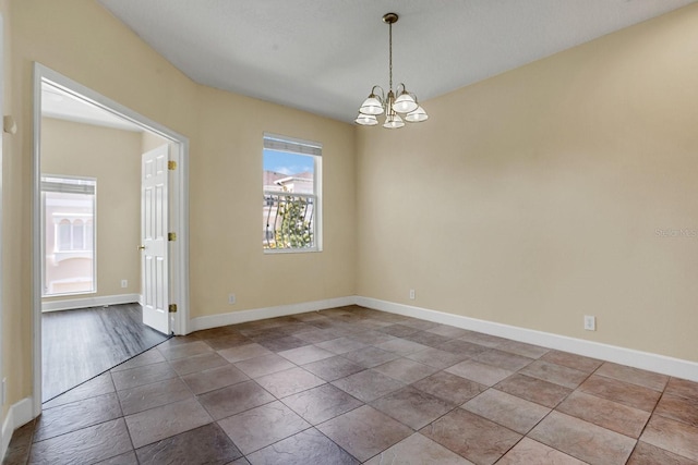 unfurnished room with a chandelier