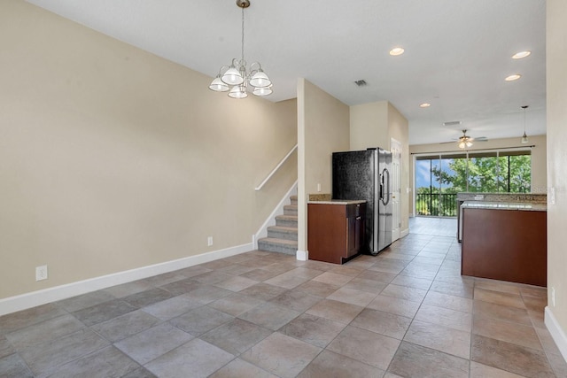 kitchen featuring hanging light fixtures, ceiling fan with notable chandelier, and stainless steel fridge