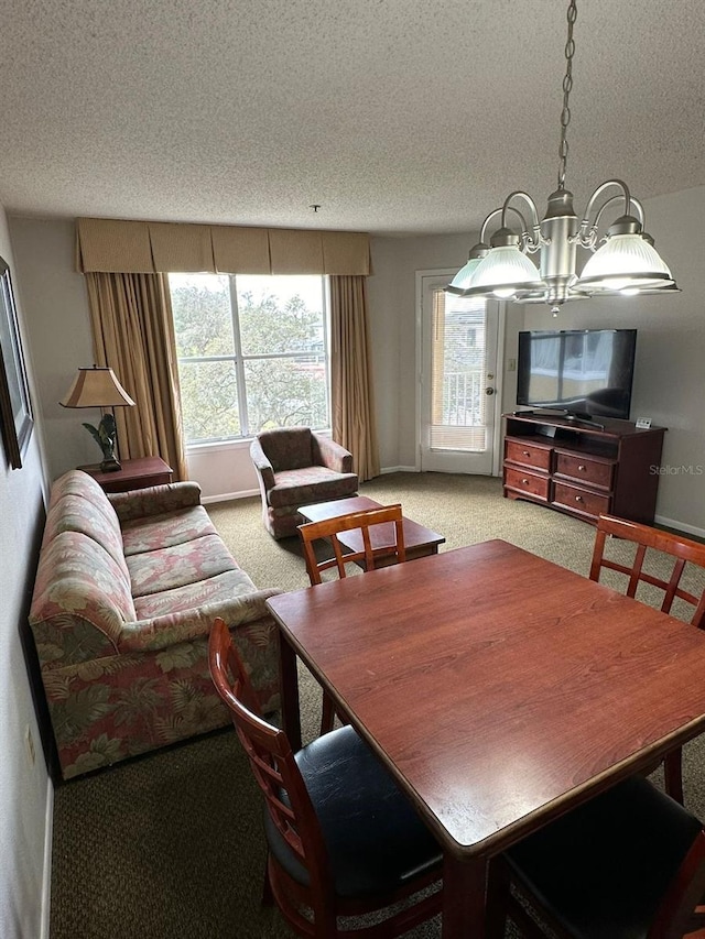 carpeted dining area featuring plenty of natural light, an inviting chandelier, and a textured ceiling