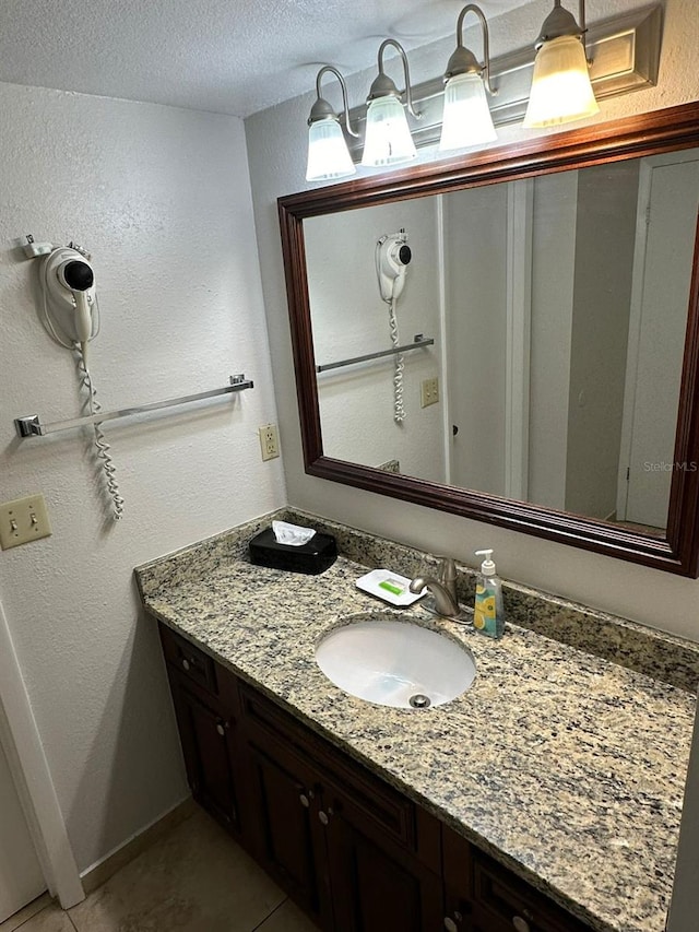 bathroom featuring tile patterned flooring, vanity, and a textured ceiling